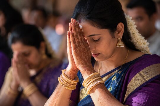 Indian woman praying during traditional religious ceremony