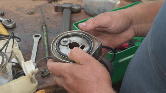 Mechanic replacing gasket on an engine oil cooler