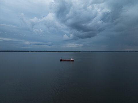 Drone view of empty cargo ship anchored in Tallinn bay Estonia under dramatic storm clouds before tempest
