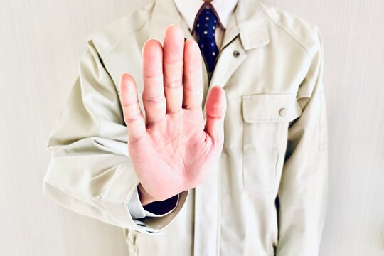 拒絶のポーズをする作業着姿の男性
