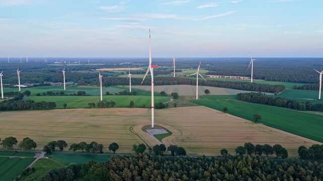 Windmill in a rural area. Offshore wind park. Wind turbines farm. Alternative renewable energy generation. Green energy concept. Organic harvest in farm field. Agricultural harvest. Crop cultivation