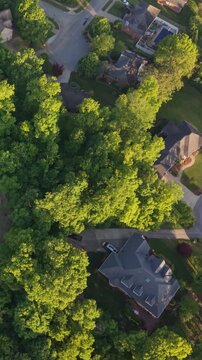 Vertical screen. Aerial perspective of a suburban area in Johnson City, Tennessee, featuring winding streets, green parks, and residential houses nestled among trees and well-maintained lawns