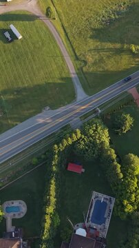 Vertical screen. Aerial perspective of suburban area Johnson City Tennessee, featuring well-maintained lawns, houses with pools, winding roads illustrating charm of community living serene environment