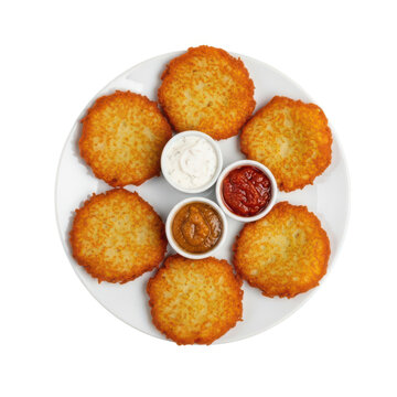A plate of six golden brown hash browns with three dipping sauces.