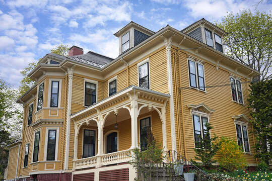 old three storey yellow clapboard house with