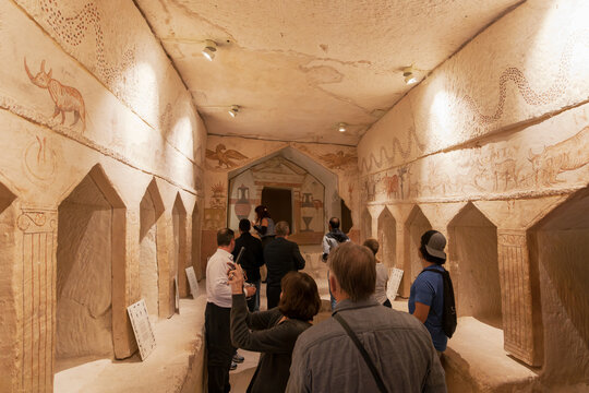 A group of tourists explore the Tomb of Apollophanes, a Hellenistic-era burial cave in Beit Guvrin-Maresha National Park, Israel.