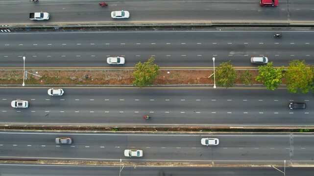 Aerial video of a busy multi-lane highway shows the movement of vehicles and urban transportation infrastructure during commutes to work, illustrating the concept of a transportation system.