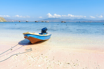 Naklejka premium Traditional Fishing Boat on White Sandy Beach with Crystal Clear Tropical Sea