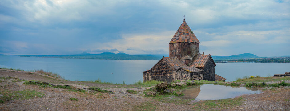 Sevanavank monastery panorama with lake Sevan and cloudy sky copy space
