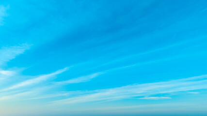 Fototapeta premium A bright, clear blue sky meets a glowing white horizon, suggesting a serene, open, and with sunlight of beautiful cloudy sky. landscape or abstract background 