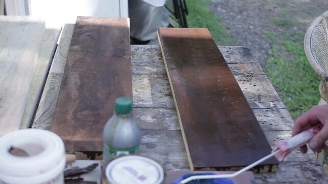 Close Up of a Man Painting Wooden Boards with Brown Paint, HD Video