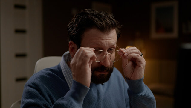 Man with poor vision putting on glasses. Close-up