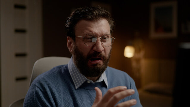 Disgusted man with glasses in home office. Close-up