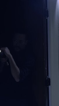 Police officer action shot searching an old warehouse with a flashlight