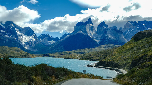 A scenic mountain road through the breathtaking landscape of Torres del Paine National Park, with turquoise waters and rugged peaks in Patagonia, Chile