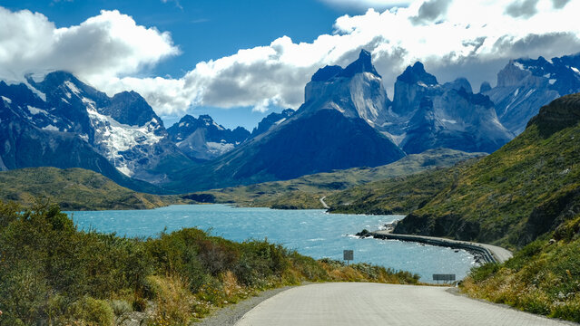 A scenic mountain road through the breathtaking landscape of Torres del Paine National Park, with turquoise waters and rugged peaks in Patagonia, Chile