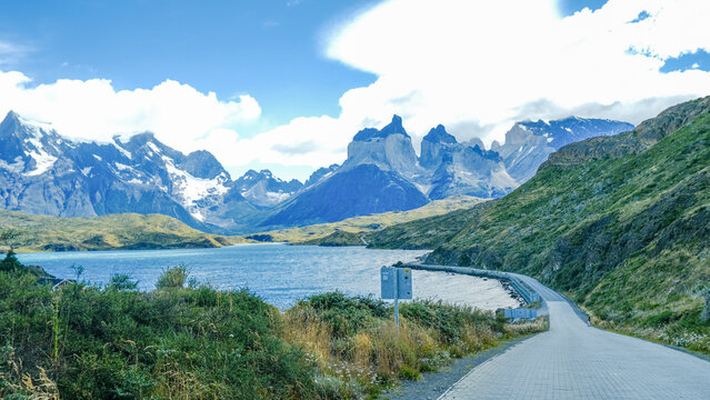 A scenic mountain road through the breathtaking landscape of Torres del Paine National Park, with turquoise waters and rugged peaks in Patagonia, Chile