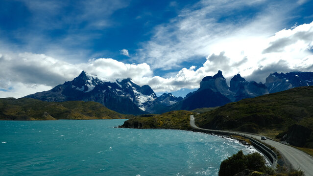 A scenic mountain road through the breathtaking landscape of Torres del Paine National Park, with turquoise waters and rugged peaks in Patagonia, Chile