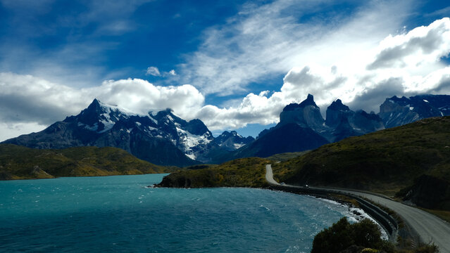 A scenic mountain road through the breathtaking landscape of Torres del Paine National Park, with turquoise waters and rugged peaks in Patagonia, Chile
