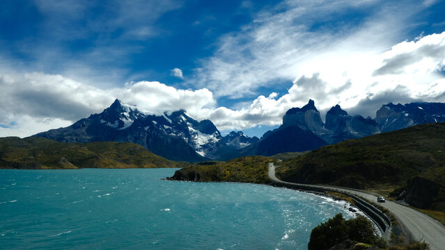 A scenic mountain road through the breathtaking landscape of Torres del Paine National Park, with turquoise waters and rugged peaks in Patagonia, Chile