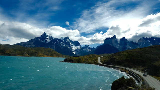 A scenic mountain road through the breathtaking landscape of Torres del Paine National Park, with turquoise waters and rugged peaks in Patagonia, Chile