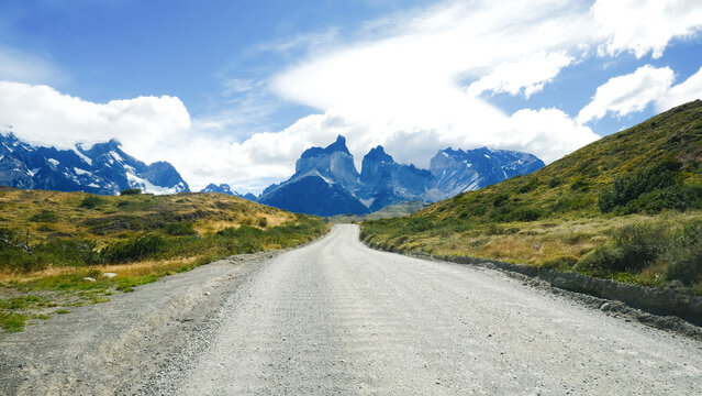 A scenic mountain road through the breathtaking landscape of Torres del Paine National Park, with turquoise waters and rugged peaks in Patagonia, Chile