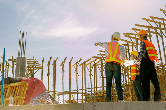 Structural engineer, architect and foreman worker with blueprints discuss, plan working for the outdoors building construction site. Construction collaboration concept