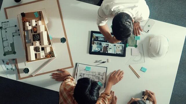 Top view of architect engineer working together and shaking hand cooperative team while making contract and dealing about budget. Aerial view of manager standing and talking about plan. Alimentation.