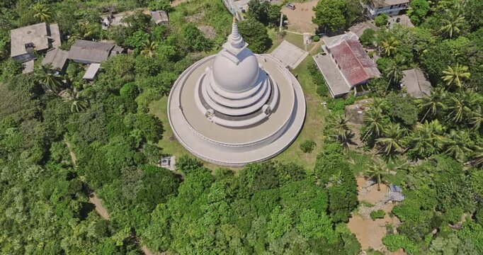 Unawatuna Sri Lanka Aerial v10 birds eye view flyover and around Japanese Peace Pagoda on Rumassala hill, tilt up reveals breathtaking jungle beach and ocean view - Shot with Mavic 3 Cine - April 2023