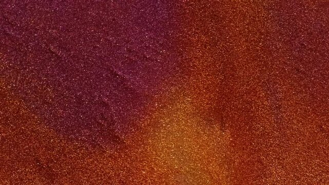 Shimmer ink mix. Glitter texture. Defocused purple orange colorful chemical droplet liquid leaking on abstract acrylic art background.