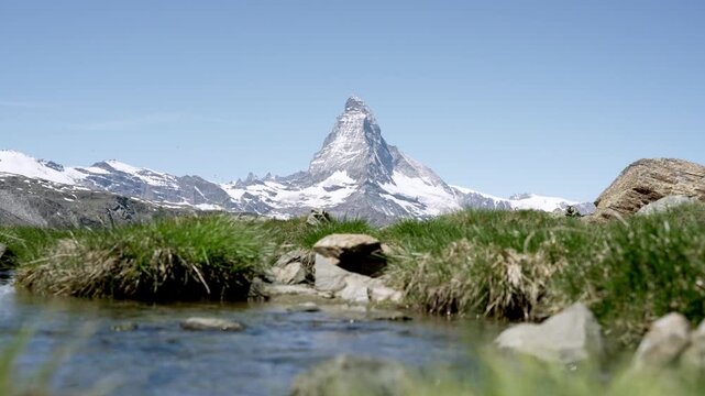 Idyllic summer landscape with the matterhorn peak reflecting in an alpine creek near zermatt
