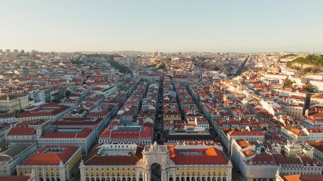 Aerial sunset of Praca do Comercio and Rua Augusta Arch in Lisbon Portugal, drone panoramic pullback, symmetrical perfection over plaza grounds