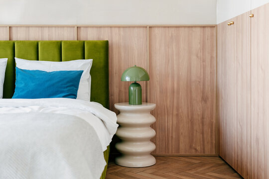 Hotel bedroom interior with comfortable bed and readng lamp on side table