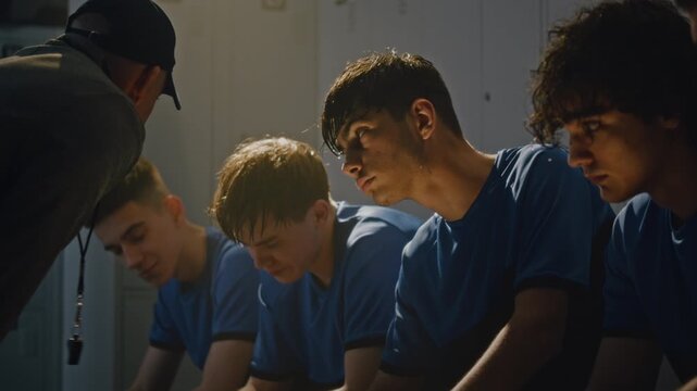 Emotional Male Football Coach Lecturing Teenage Players in Dressing Room. After Failed Match or Exhausting Training, Coach Addresses Dejected Team With Fierce Criticism, Pointing Out Mistakes.