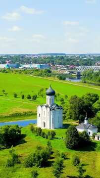 Vertical video. Russia, Bogolyubovo. Drone footage of Church of the Intercession on the Nerl. Orthodox church and a symbol of medieval Russia. Drone footage, Point of interest. Rich colors