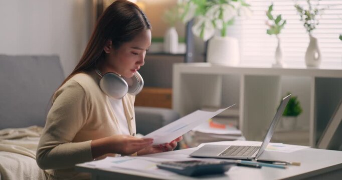 Tired Asian female financial analyst suffering from burnout and exhaustion during long hours of work from home.