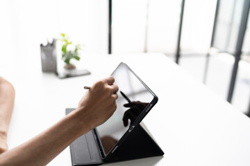 Using stylus on tablet for digital note taking and productivity technology concept. © Charlie's