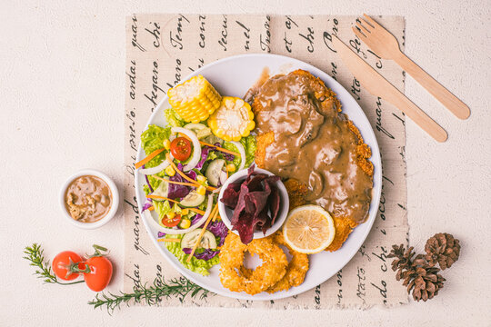 Imagine the crunch of premium, golden-brown, and juicy Chicken Katsu paired with top-notch, crispy onion rings. It doesn't stop there&mdash;fresh salad adds a burst of freshness, while sweet corn kernels ma