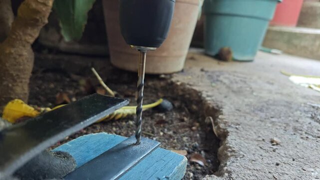Close up of a drill bit piercing through a heavy structural steel flat bar
