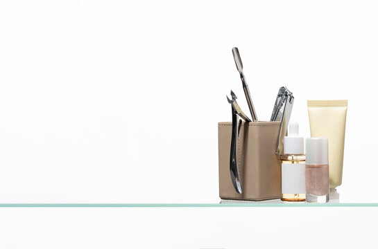 Elegant still life of manicure accessories and cosmetic bottles with cuticle oil, hand lotion, and durable steel tools for perfect fingertip maintenance.