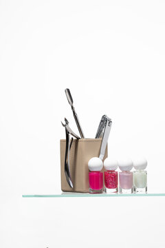Colorful nail polish set paired with professional manicure tools in a stylish holder. Featuring vibrant pink and glitter lacquers, this collection is perfect for creative nail art