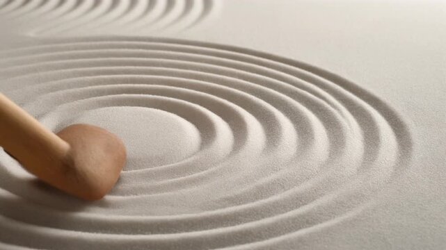 Wooden Zen Garden Rake Drawing Circles in White Sand for Mindfulness and Inner Peace