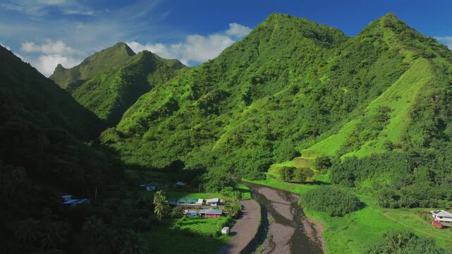 The End of the Road Teahupo'o Teahupoo Tahiti South Pacific Island French Polynesia aerial drone Vaiau River valley volcanic mountain towering jungle ridge peaks sunny afternoon blue sky forward pan