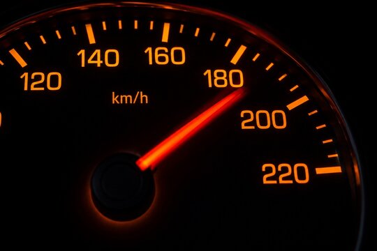 Car speedometer showing high speed with illuminated dashboard gauge