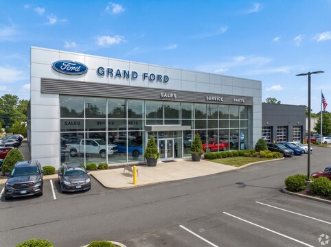 Grand Ford auto dealership with showroom and car service center building, USA