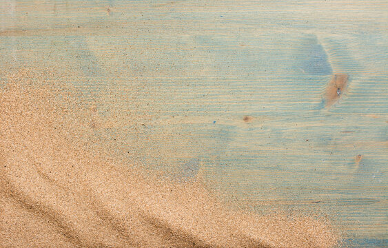 Sand on blue planked wood. Summer background with copy space. Top view