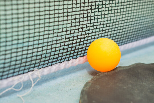 Ping pong paddles and ball on retro  blue wooden background. Rackets ruined by time