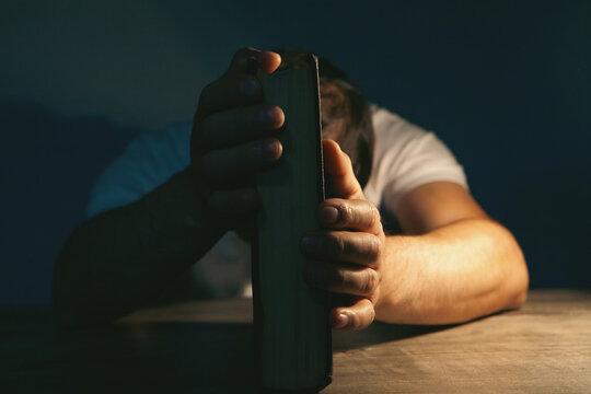 The young man was tired of reading a book in the dark