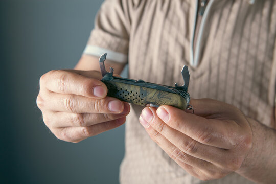 a man holds a multifunctional tool in his hand
