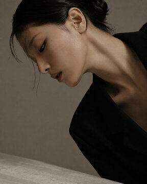 Elegant and Minimalist Studio Portrait of a Graceful Asian Woman in a Black Blazer